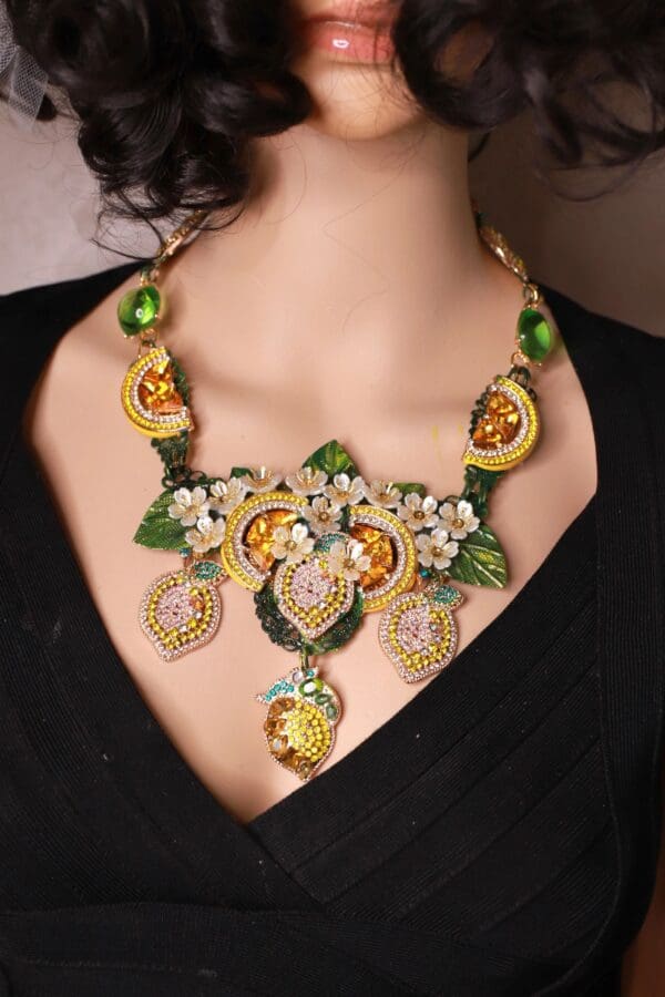 A woman wearing a necklace with flowers and leaves.