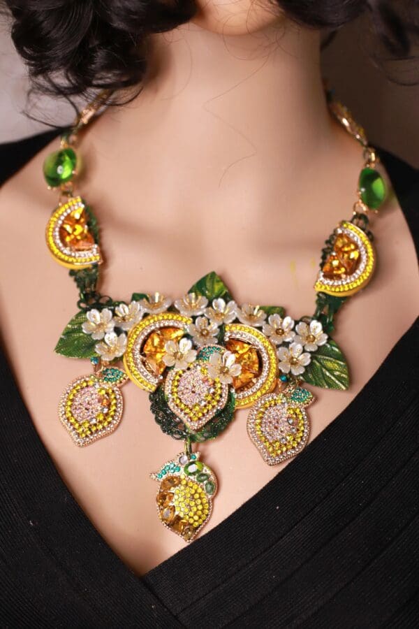 A woman wearing a necklace with lemons and flowers.