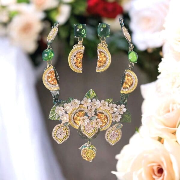 A necklace and earrings set with flowers on it.