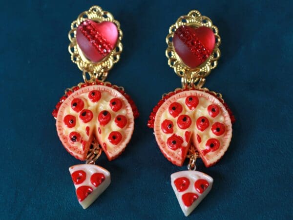 A pair of earrings with pepperoni and cheese pizza slices.