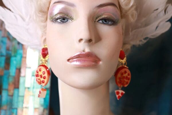 A mannequin wearing earrings with pepperoni and cheese toppings.