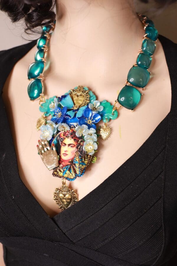 A woman wearing a necklace with a face on it.