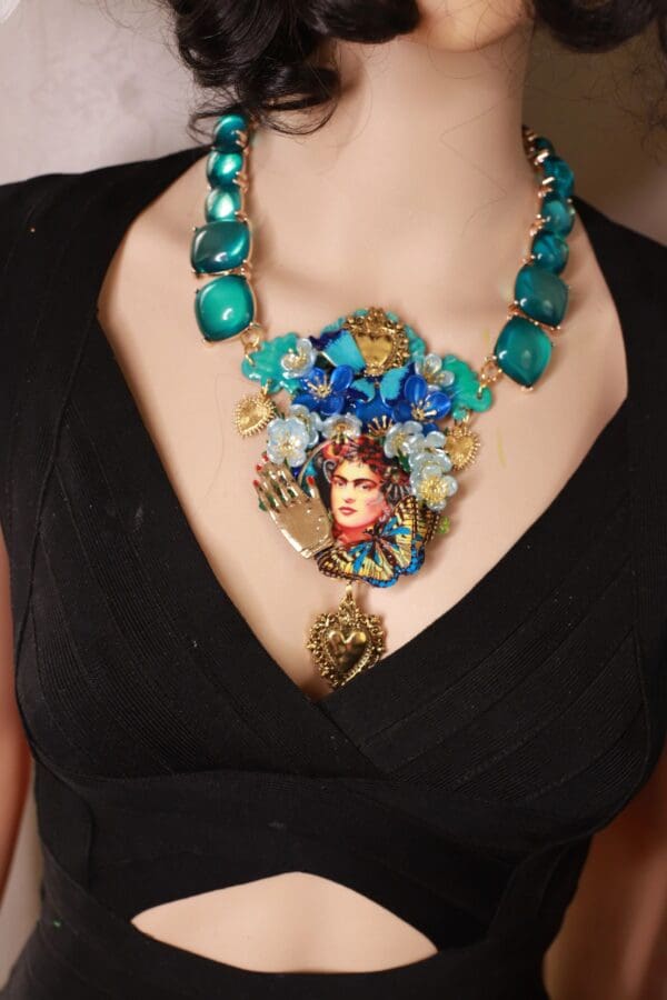 A woman wearing a necklace with blue beads and a portrait of a woman.