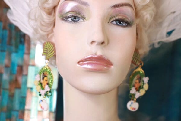 A mannequin with blonde hair and green earrings.