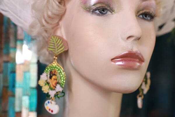 A woman wearing earrings with a face on them.