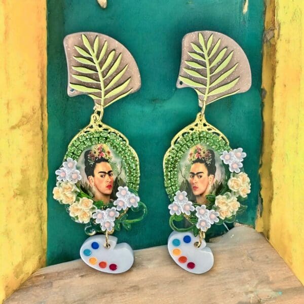 A pair of earrings with flowers and a picture.