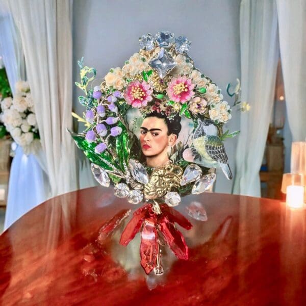 A red table with flowers and a vase on it