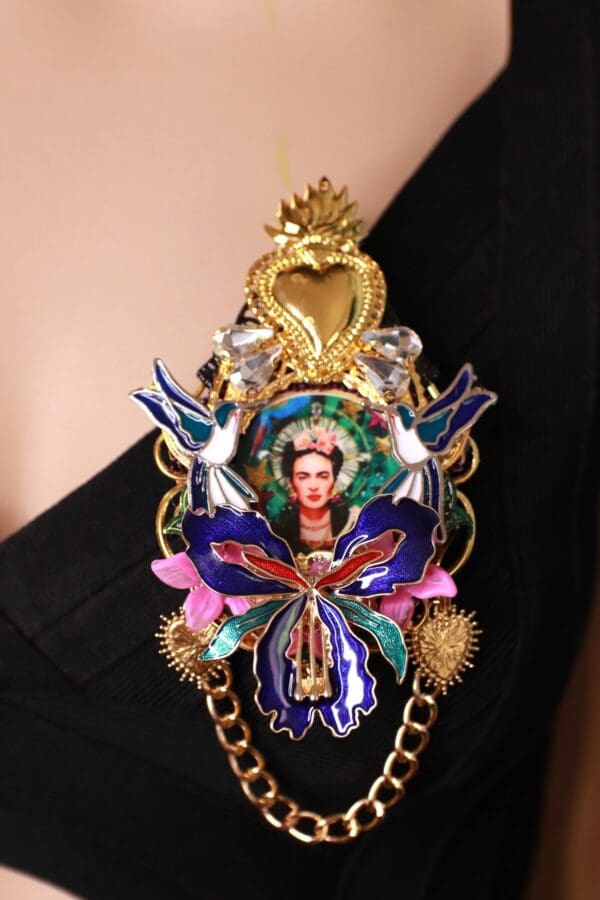 A woman wearing a necklace with a picture of frida kahlo.