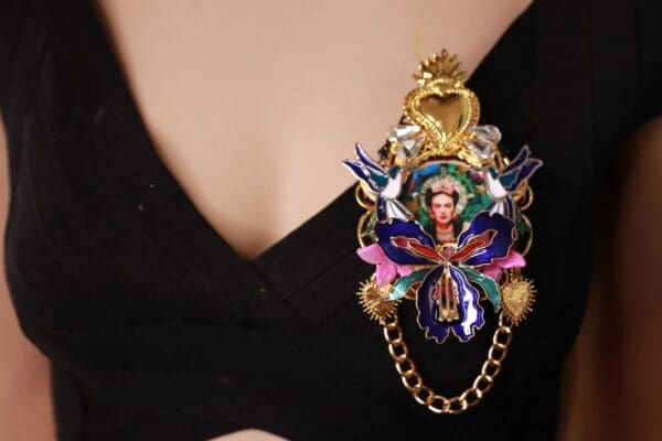 A woman wearing a necklace with a picture of frida kahlo.