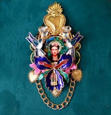 A colorful brooch with a woman and two birds.