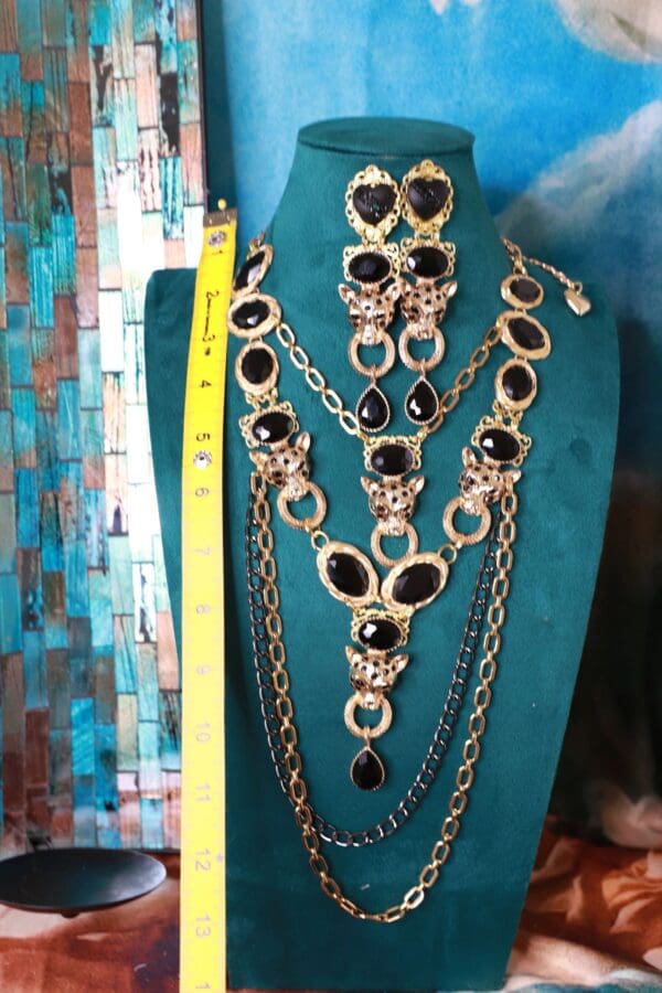 A necklace and earrings set on display in front of a wall.