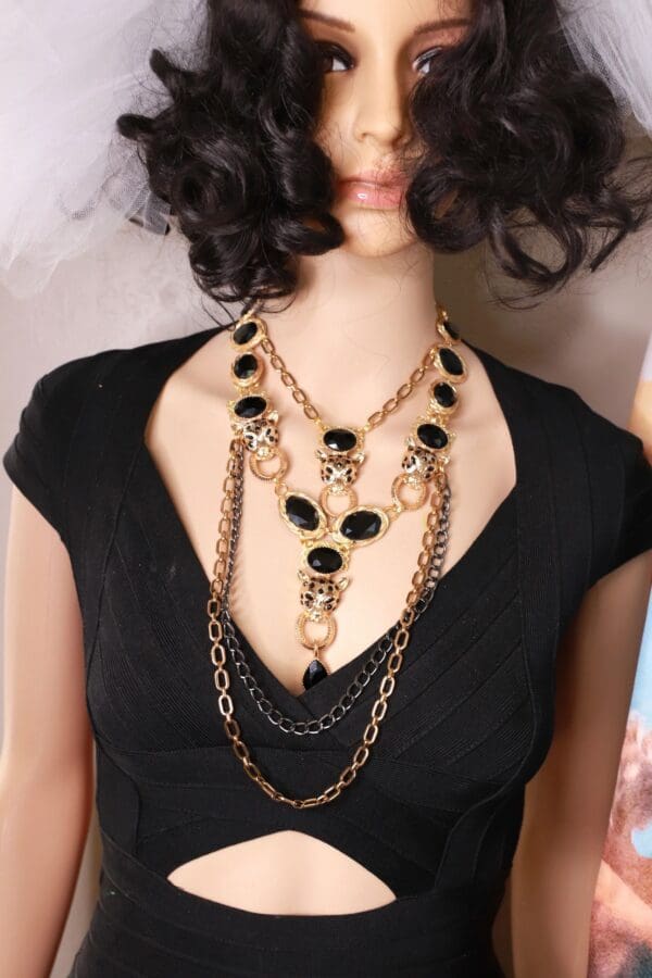 A woman wearing a black dress and necklace.