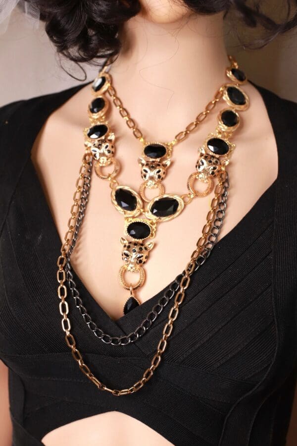 A woman wearing multiple chains and black stones.