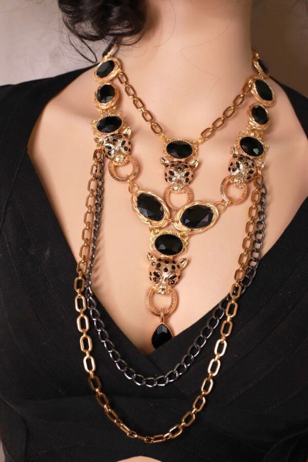 A woman wearing multiple necklaces with black stones.