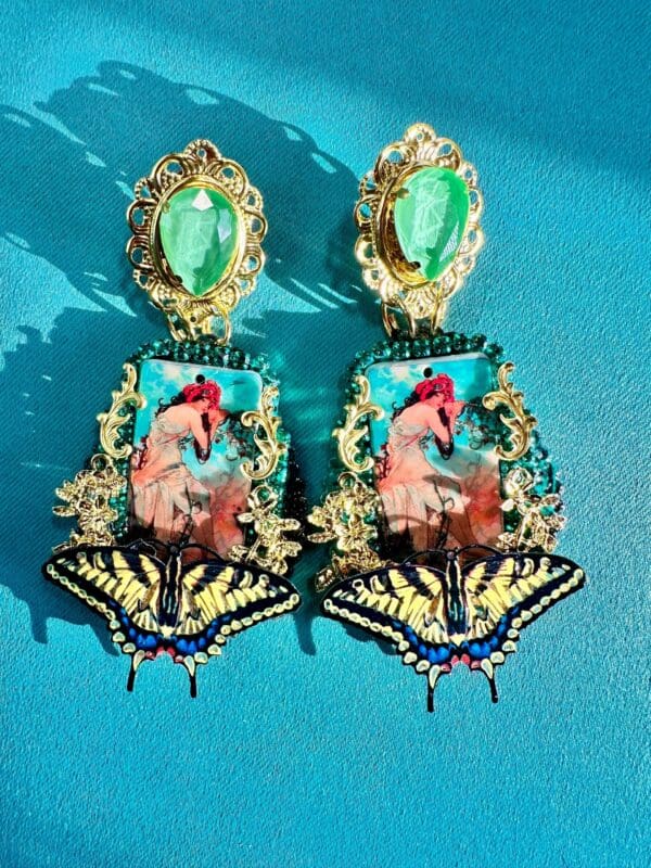 A pair of earrings with a picture and butterfly.