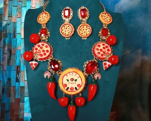 A necklace and earrings set with red peppers.