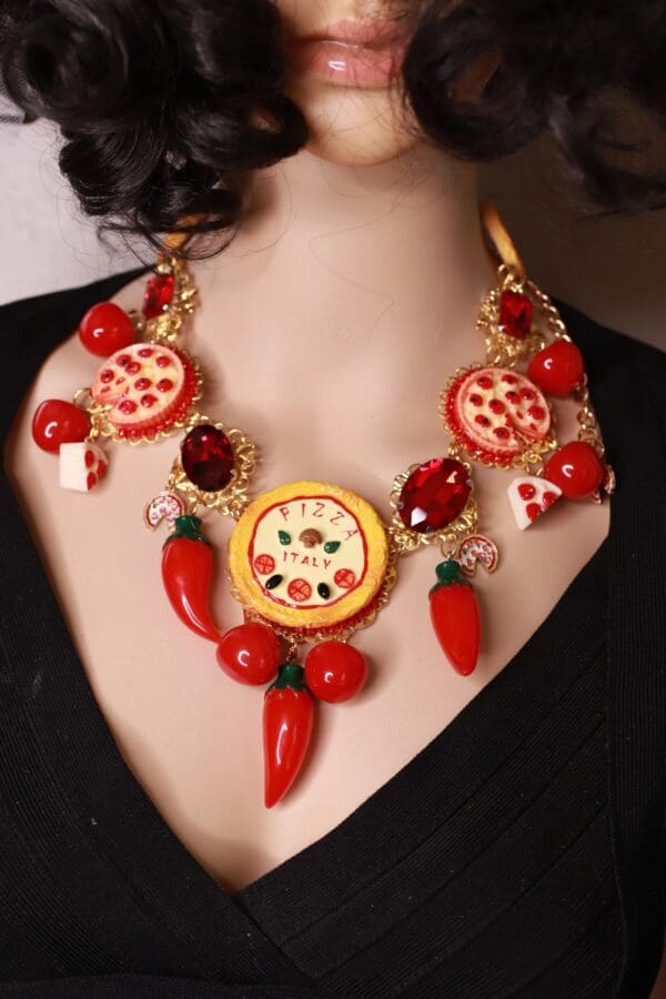 A woman wearing a necklace with pepperoni and cheese.