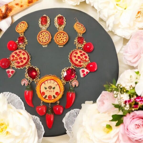 A necklace and earrings set with flowers around it.