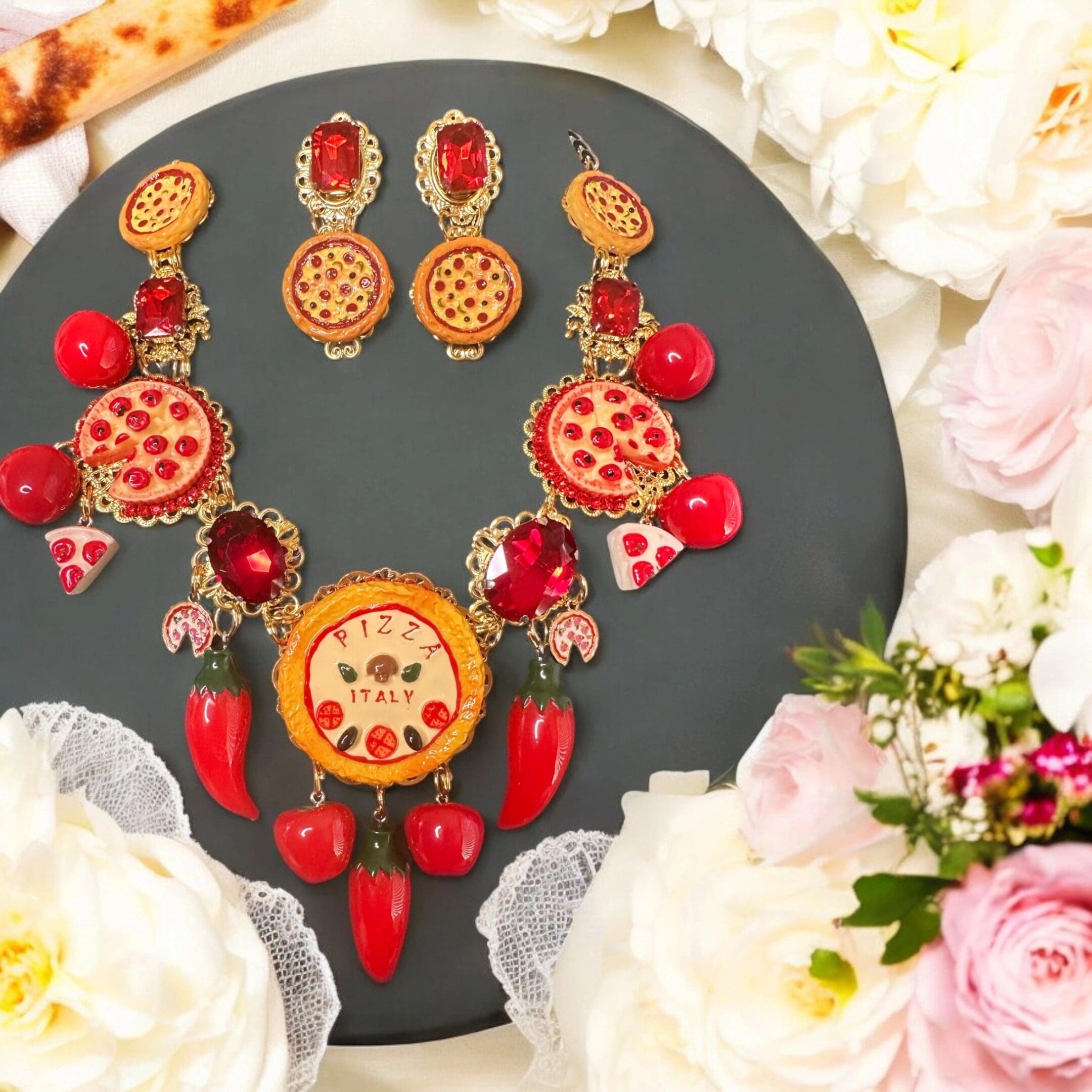 A necklace and earrings set with flowers around it.