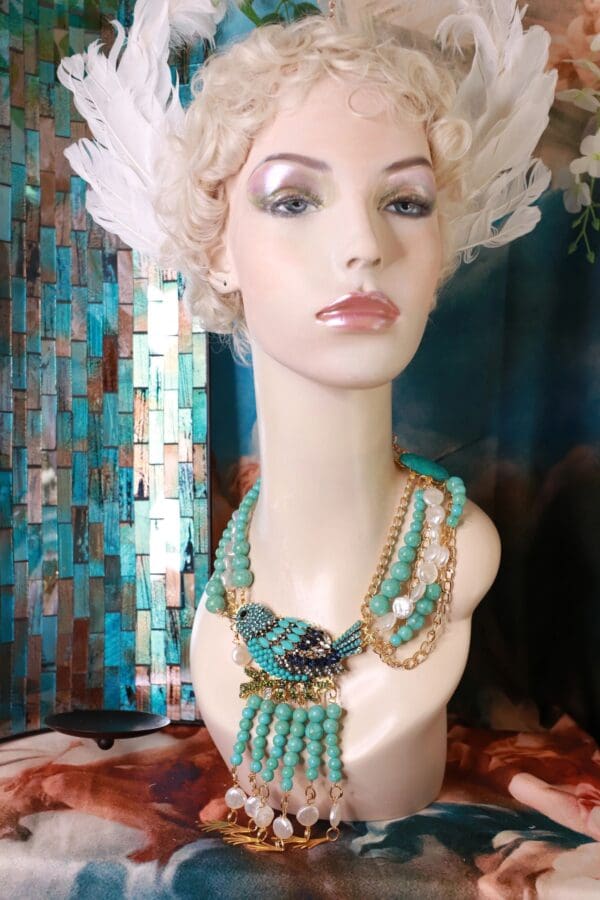 A mannequin wearing a hat and jewelry display.