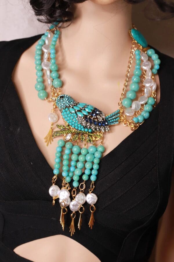 A woman wearing a necklace with beads and pearls.