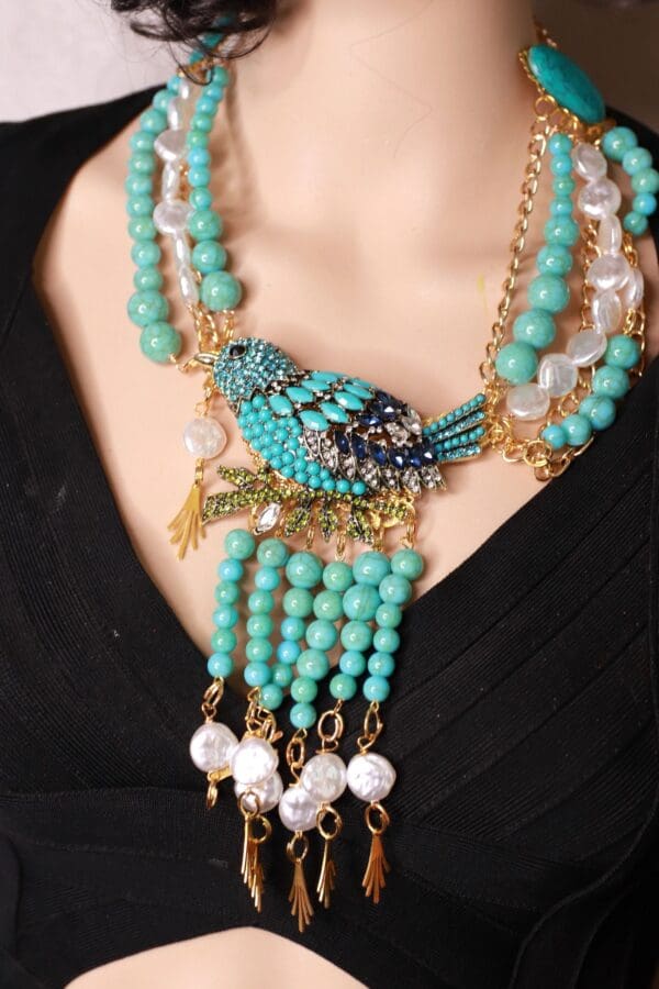 A woman wearing a necklace with beads and pearls.