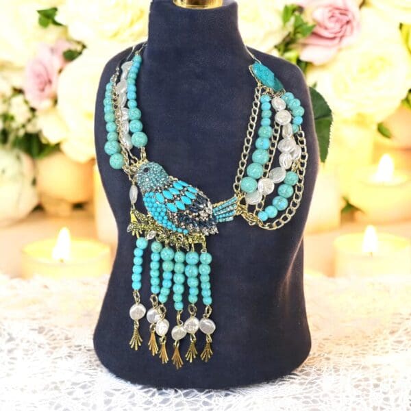 A necklace is displayed on a black stand.