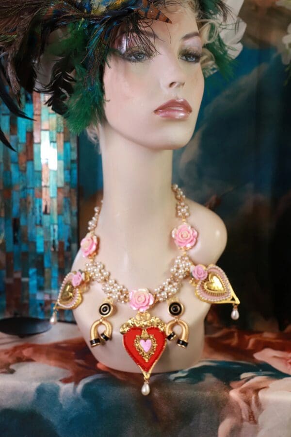 A mannequin wearing a necklace with hearts and flowers.