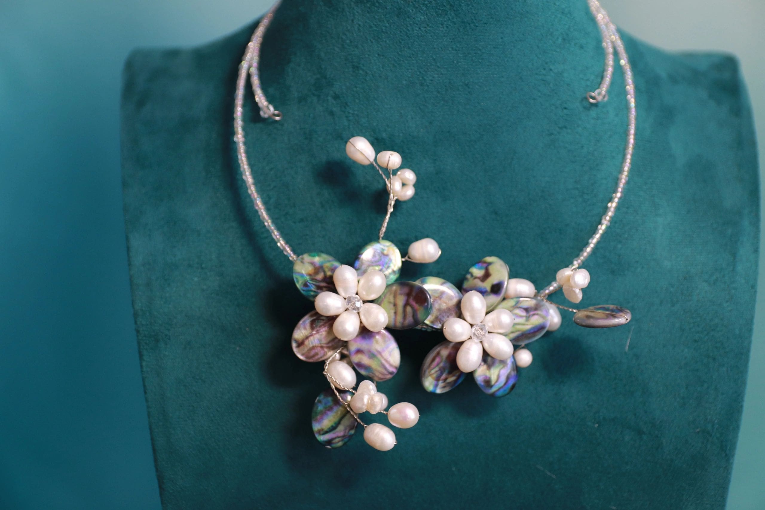 A necklace with flowers and pearls on it.