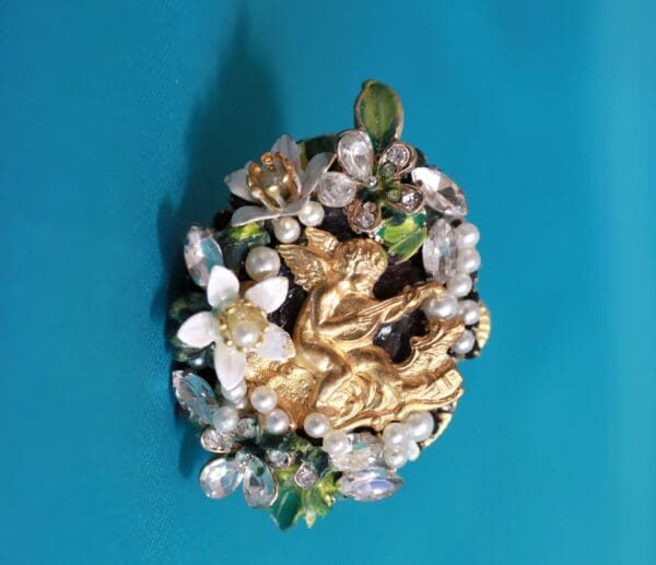 A close up of a brooch on a blue surface