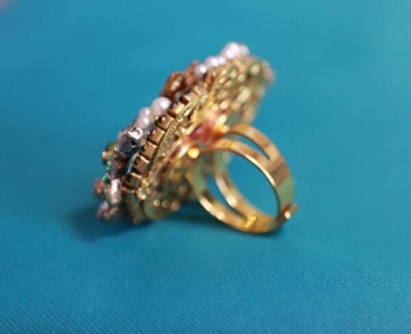 A gold ring with pearls and stones on it