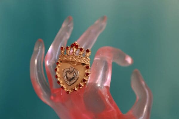 A hand holding something with a crown on it