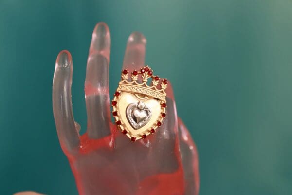 A hand with a heart on it and crown in the middle.