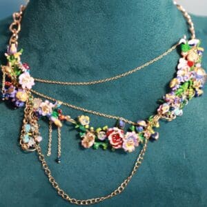 A necklace with flowers and chains on the neck of a woman.