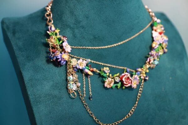 A necklace with flowers and chains on the neck of a woman.