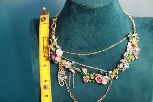 A necklace is shown on the bust of a mannequin.
