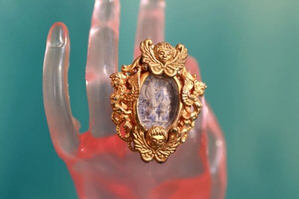 A gold ring with a picture of a woman in it.