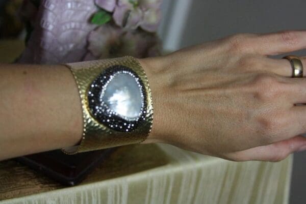 A woman wearing a bracelet with a heart on it.