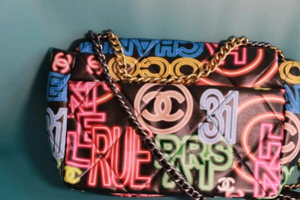 A close up of the chanel bag with neon letters