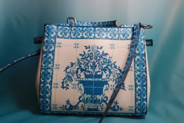 A blue and white purse with a floral design.
