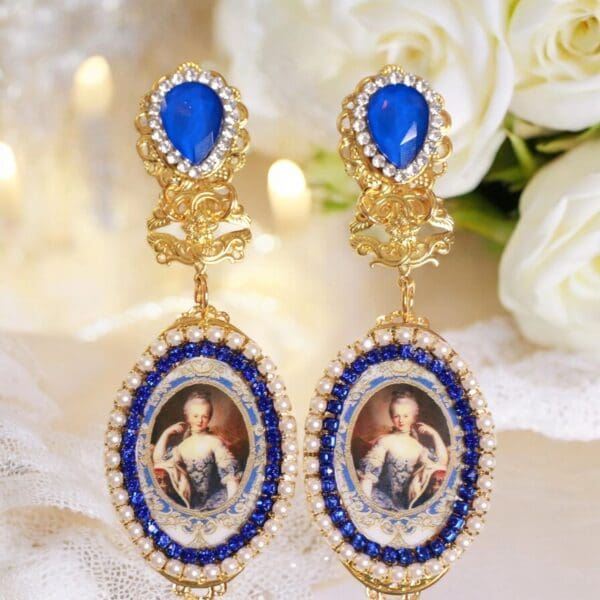 A pair of earrings with blue stones and gold frame.