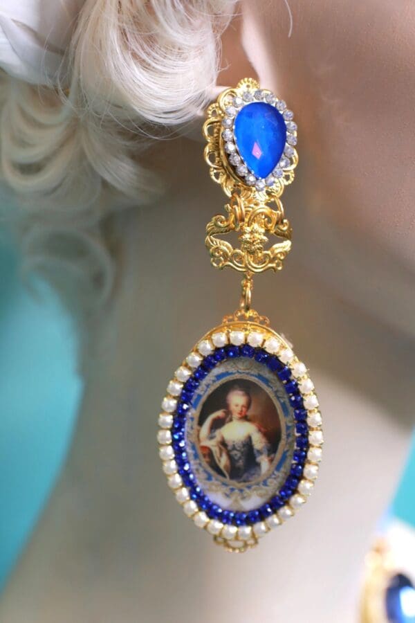A woman wearing a blue and white earring.