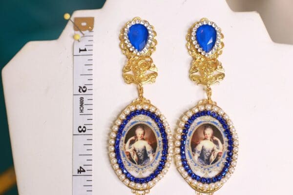 A pair of earrings with blue stones and gold trim.