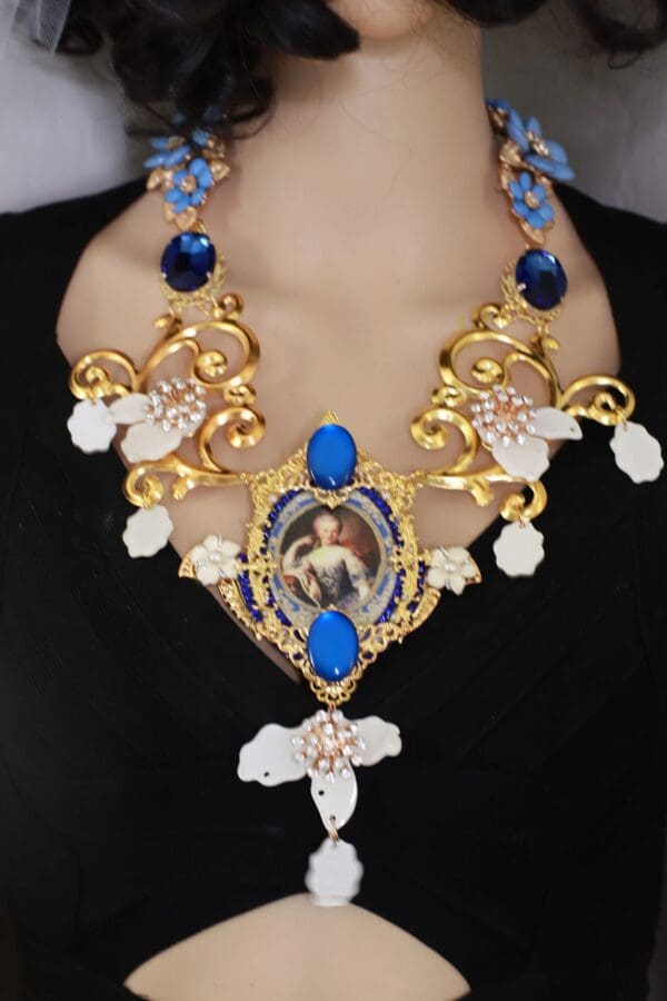 A woman wearing a necklace with blue and white flowers.