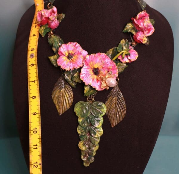 A necklace with pink flowers and leaves on it