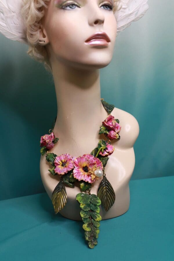 A mannequin wearing a necklace with pink flowers.