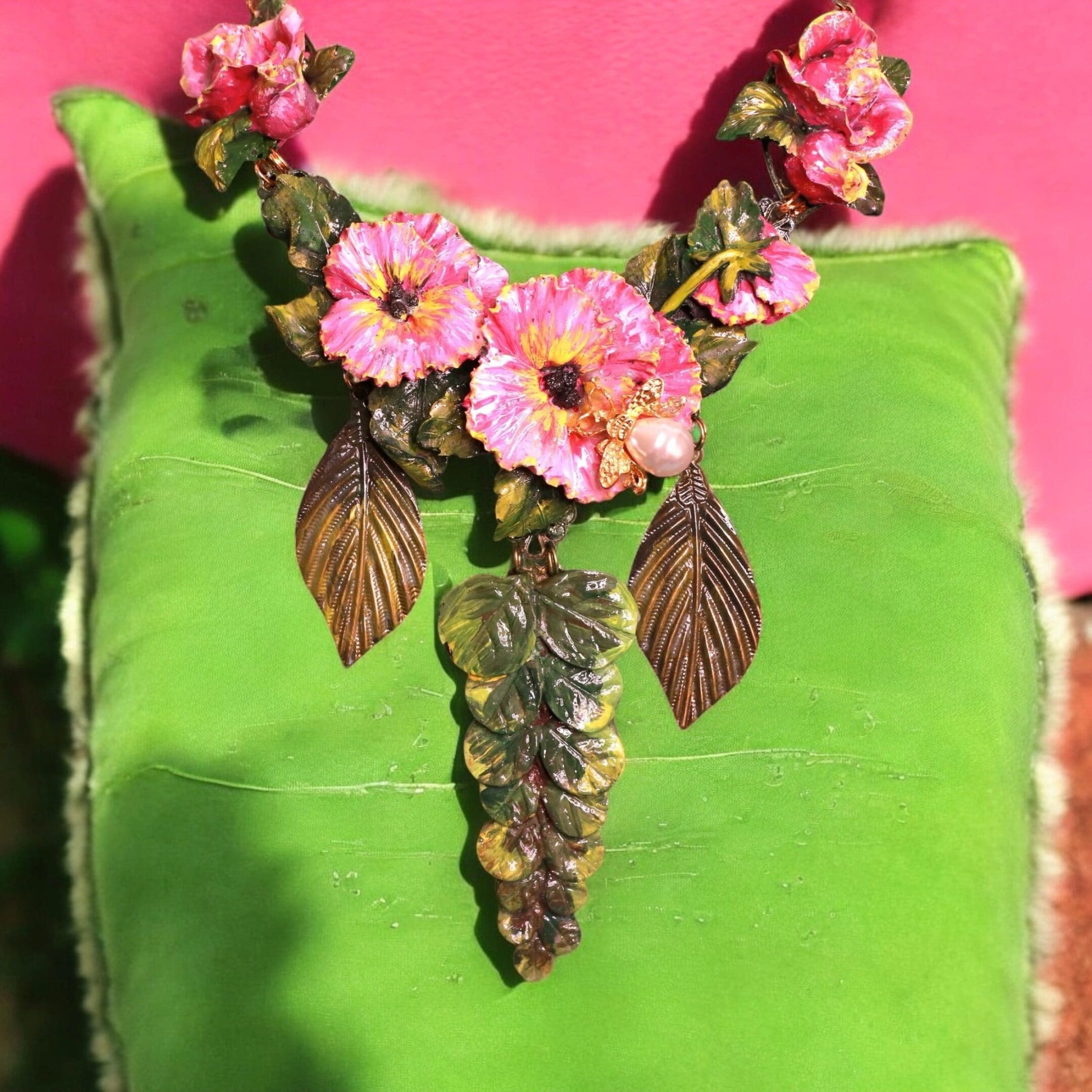 A green bag with pink flowers and leaves on it.