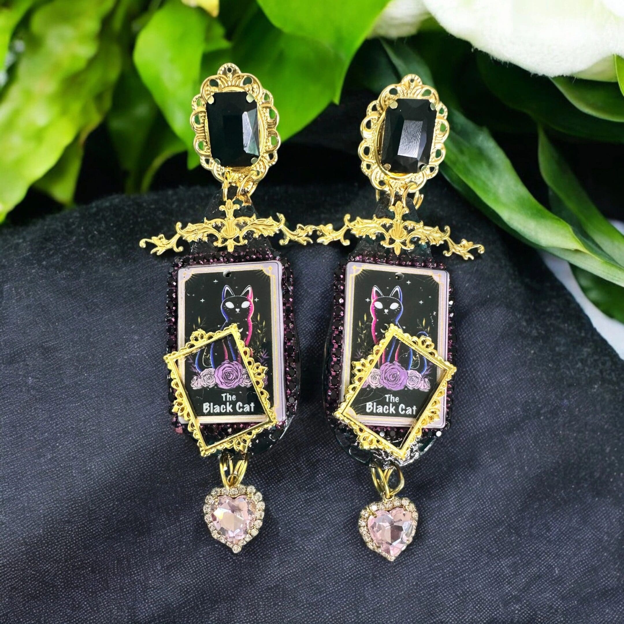 A pair of earrings with a picture and a black background