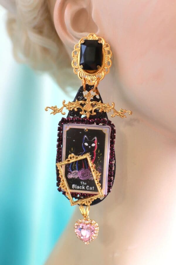 A woman wearing a pair of earrings with a picture on it.