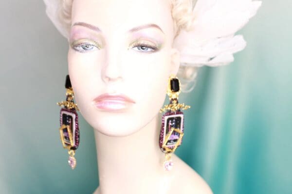 A woman wearing earrings with purple and black design.